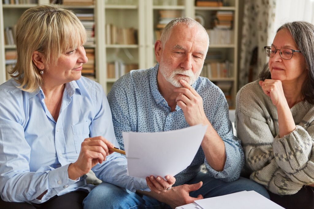 Steuerberaterin und Senioren schauen auf Antrag oder Formular zur Altersvorsorge und Rente