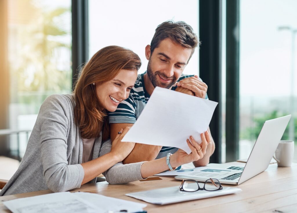 Documents, finance and couple planning budget for tax, bills and savings on laptop with banking, online payment and investment. People, paperwork and happy conversation on financial growth strategy.