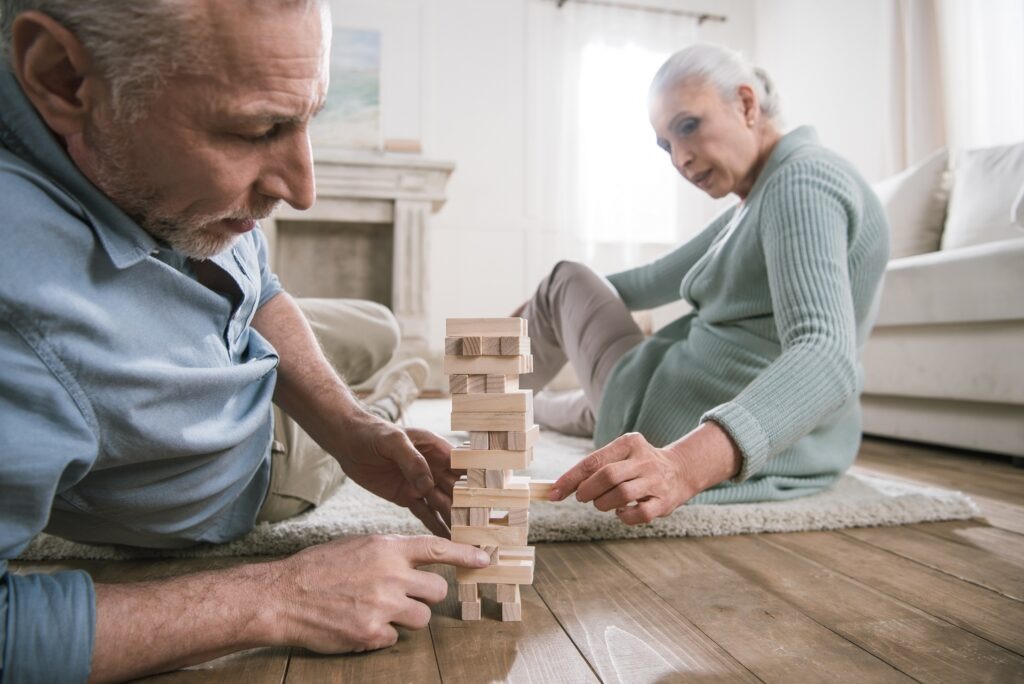 senior couple playing wood blocks game at home