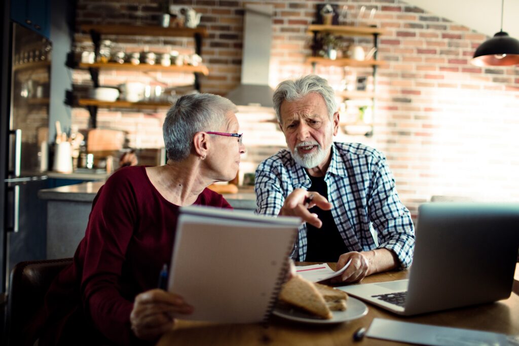 Worried senior couple going over bill debt at home